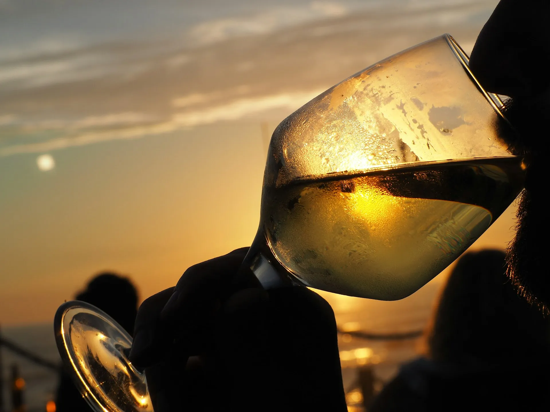 Et glas hvidvin mod solnedgang
