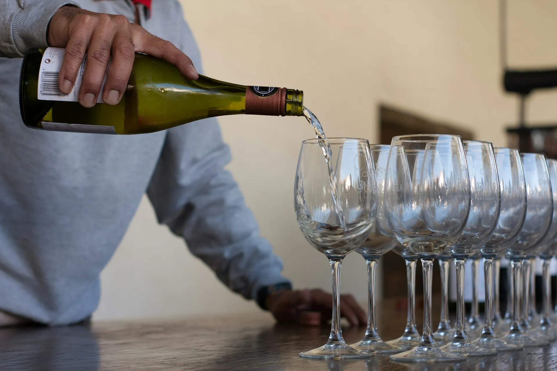 Hvidvin skænkes i en række glas