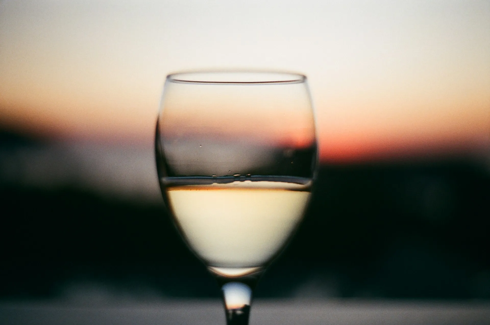 Et glas hvidvin i solnedgang