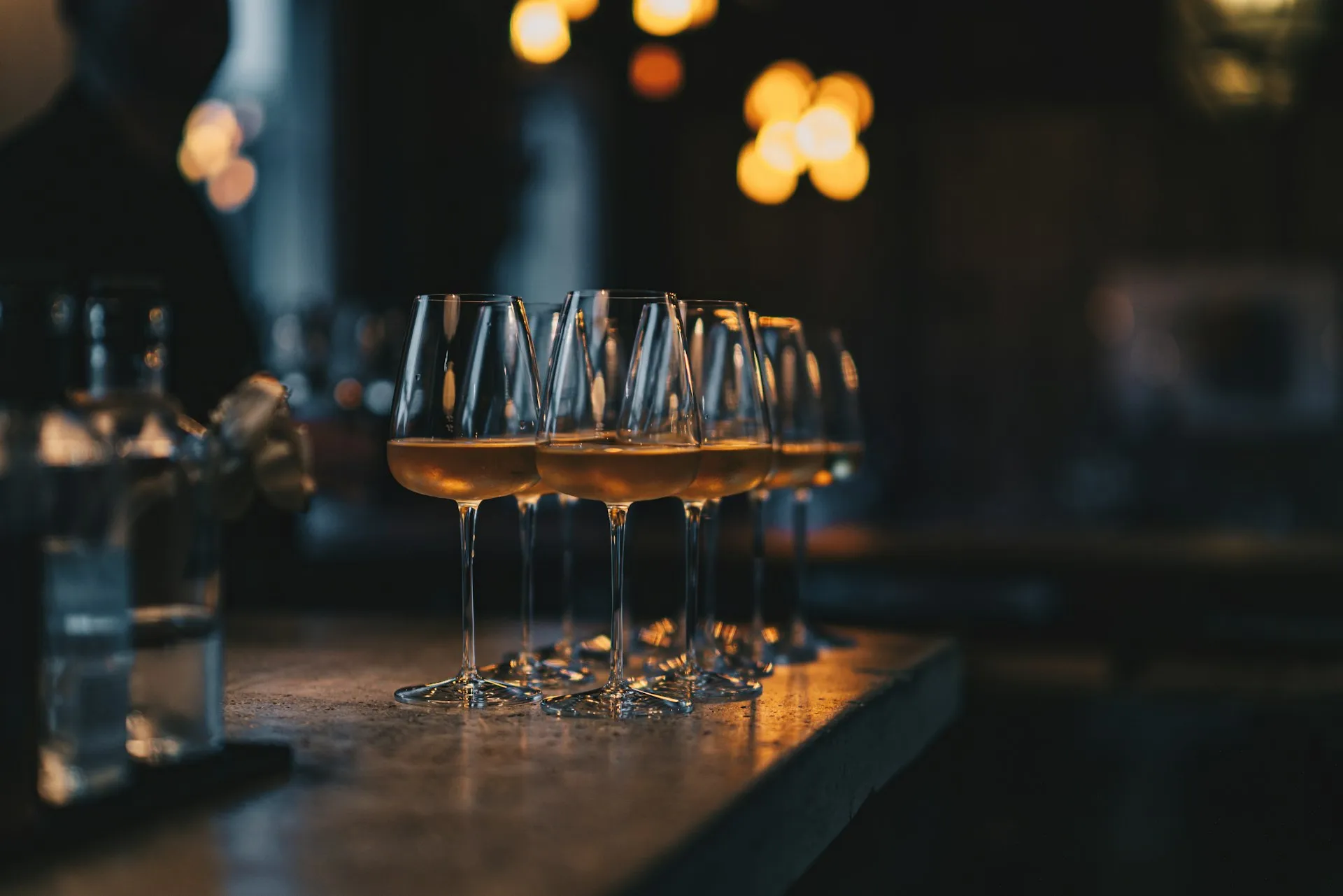 Glas med rav-farvet vin på en bardisk
