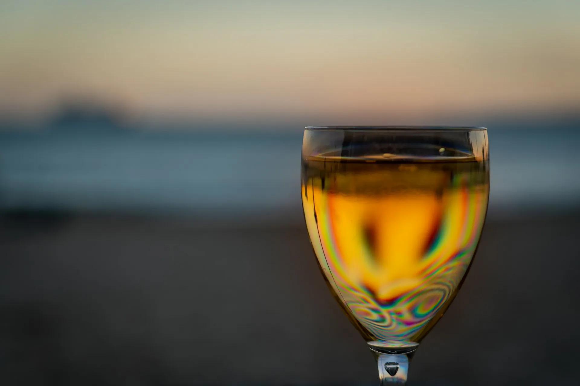 Et glas gylden hvidvin i modlys